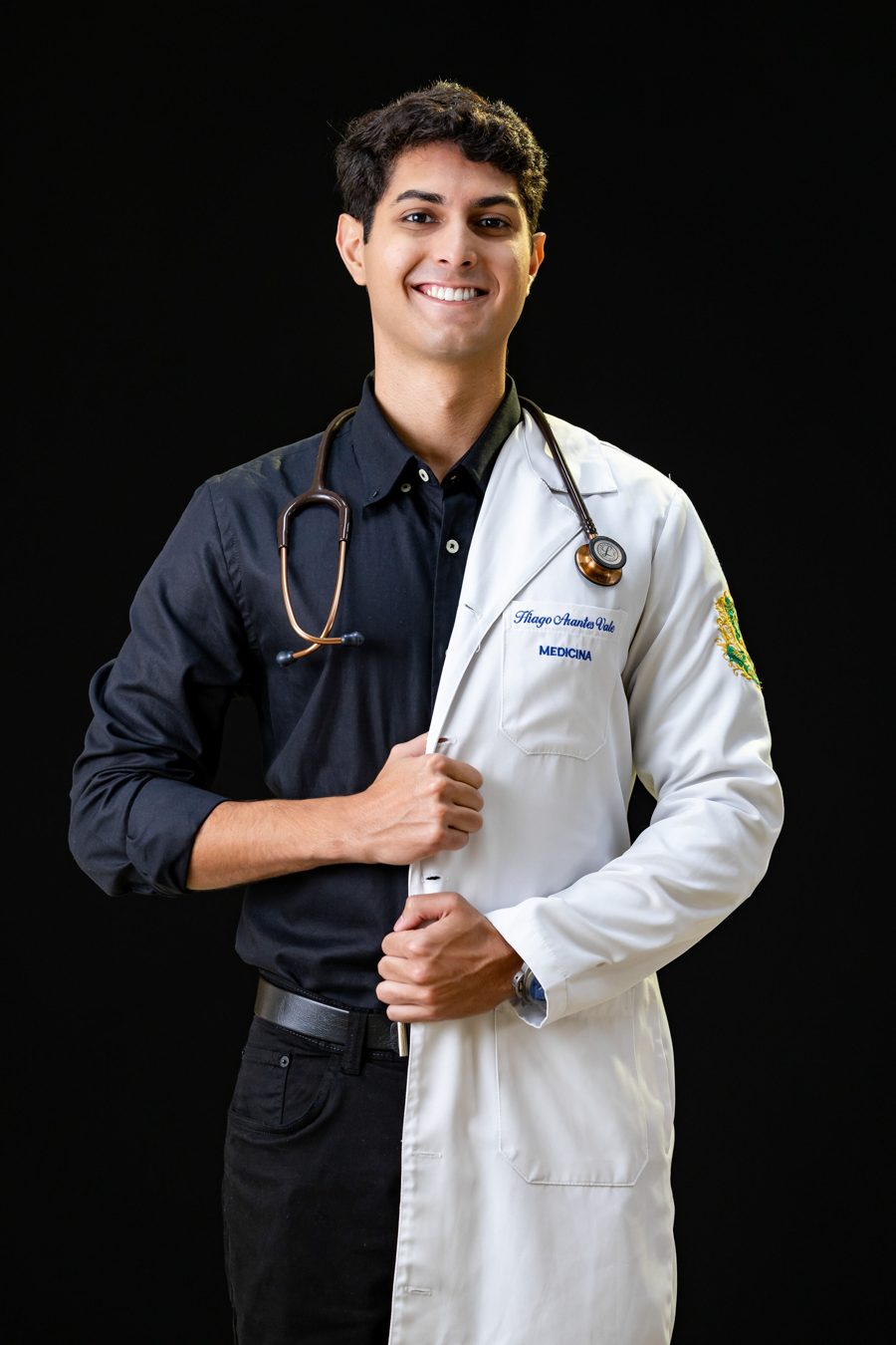 Hiago Arantes Vale, de jaleco e estetoscópio, sorrindo.